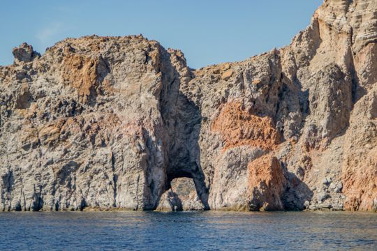 Rust-coloured rock formations along the waterline